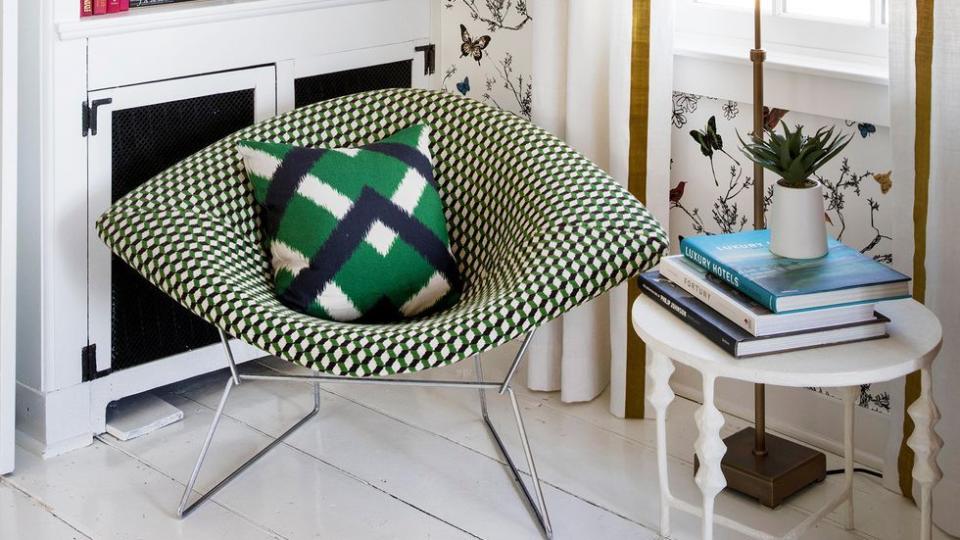 a white and green printed chair in front of a bookcase