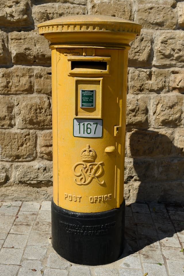 A yellow painted Post Office post box in Nicosia, Cyprus (Andrew Matthews/PA)