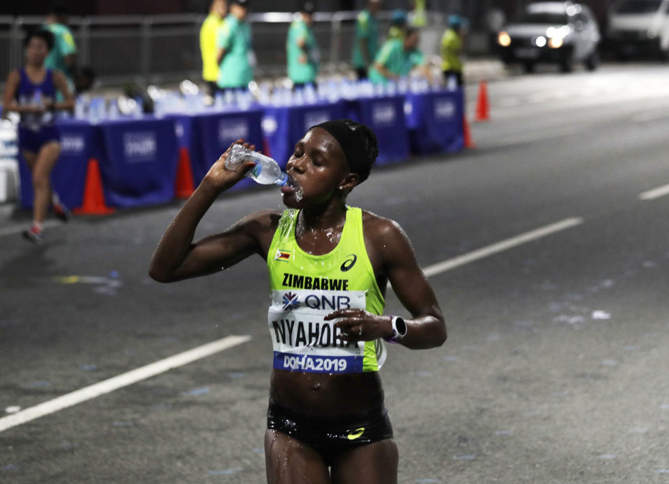 Rutendo Joan Nyahora, of Zimbabwe, drinks water during the women's marathon at the World Athletics Championships in Doha, Qatar, Saturday, Sept. 28, 2019. (AP Photo/Nariman El-Mofty)