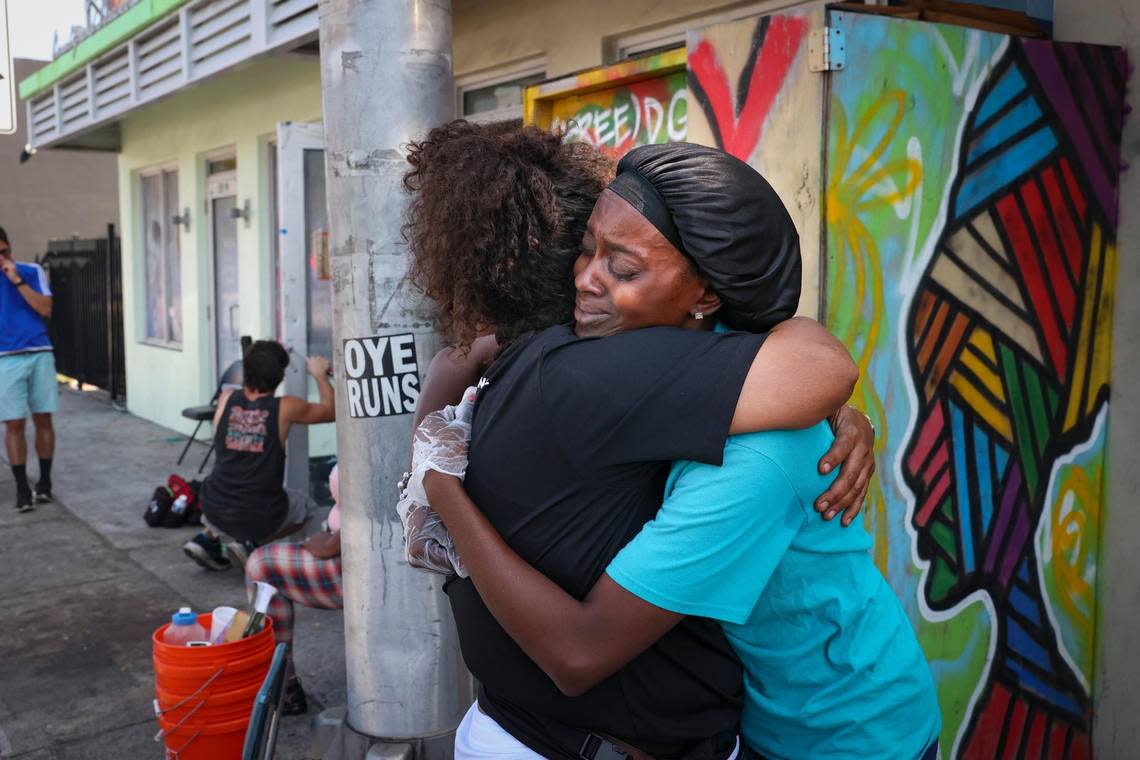 Sherina Jones, right, founder and operator of the Village FREEdge food pantry, hugs Berlinda Dixon, retired nurse who works at the nearby clinic, while the landlord has the locks changed behind them during eviction of the food pantry on Monday, March 6, 2023, in Liberty City. The clinic that works hand in hand with the food pantry got evicted in February also by Gator Investments.