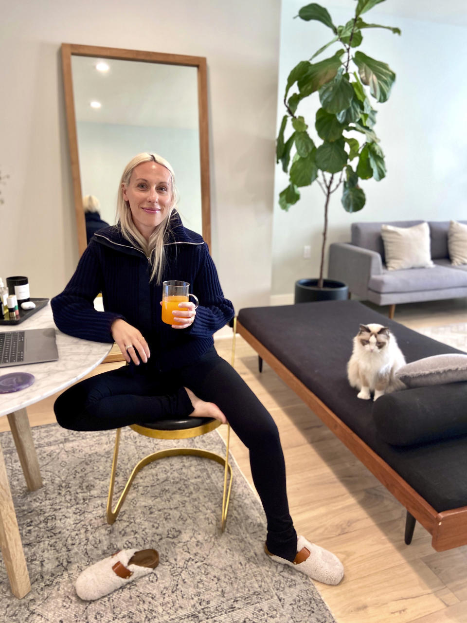 In this April 5, 2020 photo, Goop fashion director Ali Pew is poses in Los Angeles. After weeks stuck in isolation, bodies molded into beds and couches glued to TVs and computers, with little to delineate weekends from weekdays, a pronounced fashion trend is emerging in loungewear. It's comfy, everyday clothing with a bit more refinement, unfussy, minimal, but pulled together enough for a zoom conference call with your boss. (Oliver Clark via AP)
