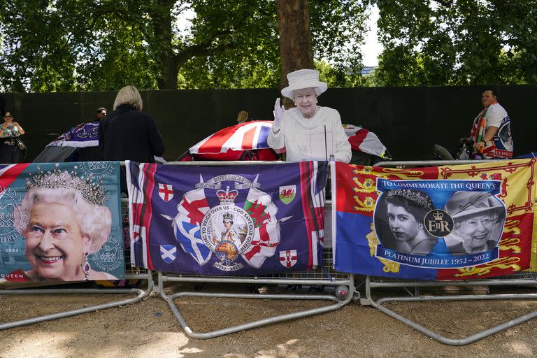 Fanáticos colocan banderas en las vallas a lo largo de The Mall en Londres, el 1º de junio de 2022, mientras acampan antes del inicio del Jubileo de la Reina