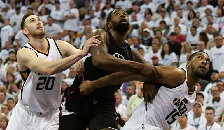 Gordon Hayward (L) and Derrick Favors of the Utah Jazz try to block DeAndre Jordan of the Los Angeles Clippers in Game Three of the Western Conference Quarterfinals