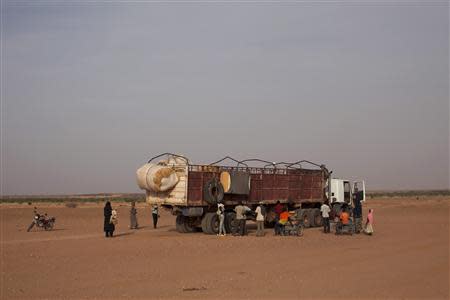 Nigeriens, who are travelling north in the direction of Libya, board a truck in Agadez March 17, 2014. Picture taken March 17, 2014. REUTERS/Joe Penney