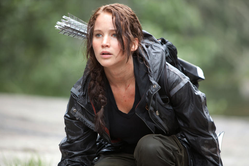 In this image provided by Lionsgate, Jennifer Lawrence portrays Katniss Everdeen in a scene from "The Hunger Games." "Bridesmaids" and "The Hunger Games" are battling for the most buckets of golden popcorn at the MTV Movie Awards. The raunchy comedy and survival saga are the top nominees at Sunday's 21st annual extravaganza with eight nods apiece. (AP Photo/Lionsgate, Murray Close)