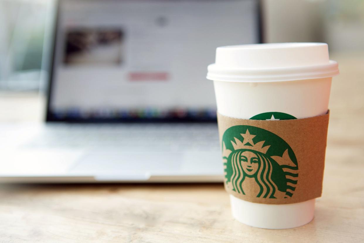 small starbucks cup in front of laptop