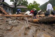 <p>Local residents walk on driftwood blocking the way to their homes as torrential rain hit on July 6, 2017 in Toho, Fukuoka, Japan. T (Photo: The Asahi Shimbun via Getty Images) </p>