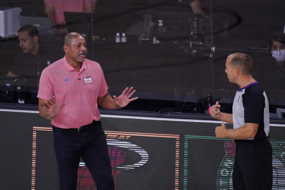 Los Angeles Clippers head coach Doc Rivers, left, questions a call during the first half of an NBA conference semifinal playoff basketball game against the Denver Nuggets, Tuesday, Sept. 15, 2020, in Lake Buena Vista, Fla. (AP Photo/Mark J. Terrill)