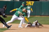 San Francisco Giants' Casey Schmitt steals second base as Oakland Athletics third baseman Aledmys Diaz loses the ball during the seventh inning of a spring training baseball game in Oakland, Calif., Sunday, March 26, 2023. (AP Photo/Eric Risberg)