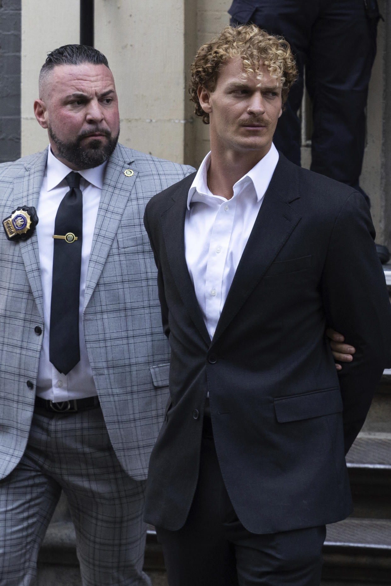 Daniel Penny, center, is walked by New York Police Department detectives detectives out of the 5th Precinct on Friday, May. 12, 2023 in New York. Manhattan prosecutors announced Thursday they would bring the criminal charge against Penny, 24, a U.S. Marine Corps veteran, in the May 1 death of 30-year-old Jordan Neely. (AP Photo/Jeenah Moon)