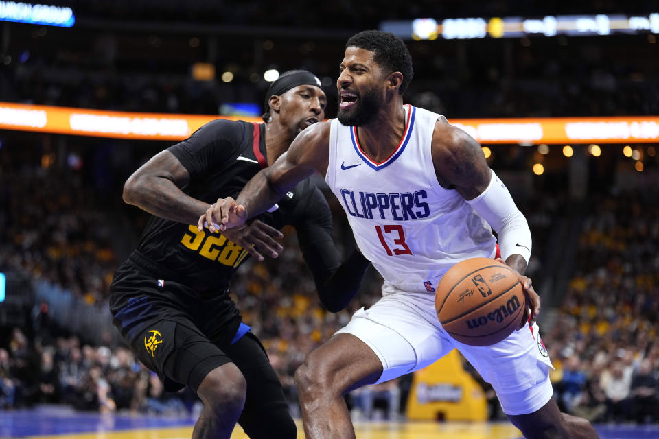 Los Angeles Clippers forward Paul George (13) drives to the basket against Denver Nuggets guard Kentavious Caldwell-Pope during the second half of an NBA basketball in-season tournament game Tuesday, Nov. 14, 2023, in Denver. (AP Photo/Jack Dempsey)