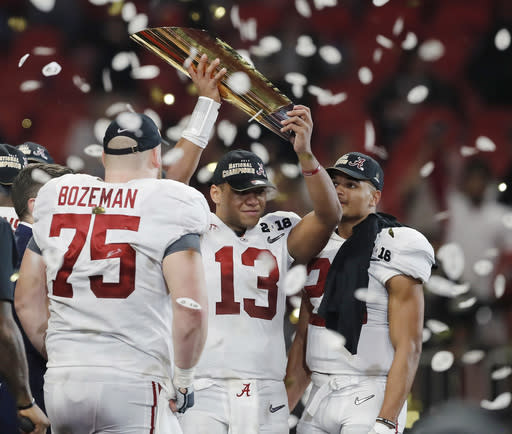 Alabama’s Tua Tagovailoa holds up the championship trophy after overtime of the NCAA college football playoff championship game against Georgia Monday, Jan. 8, 2018, in Atlanta. Alabama won 26-23. (AP Photo/David Goldman)