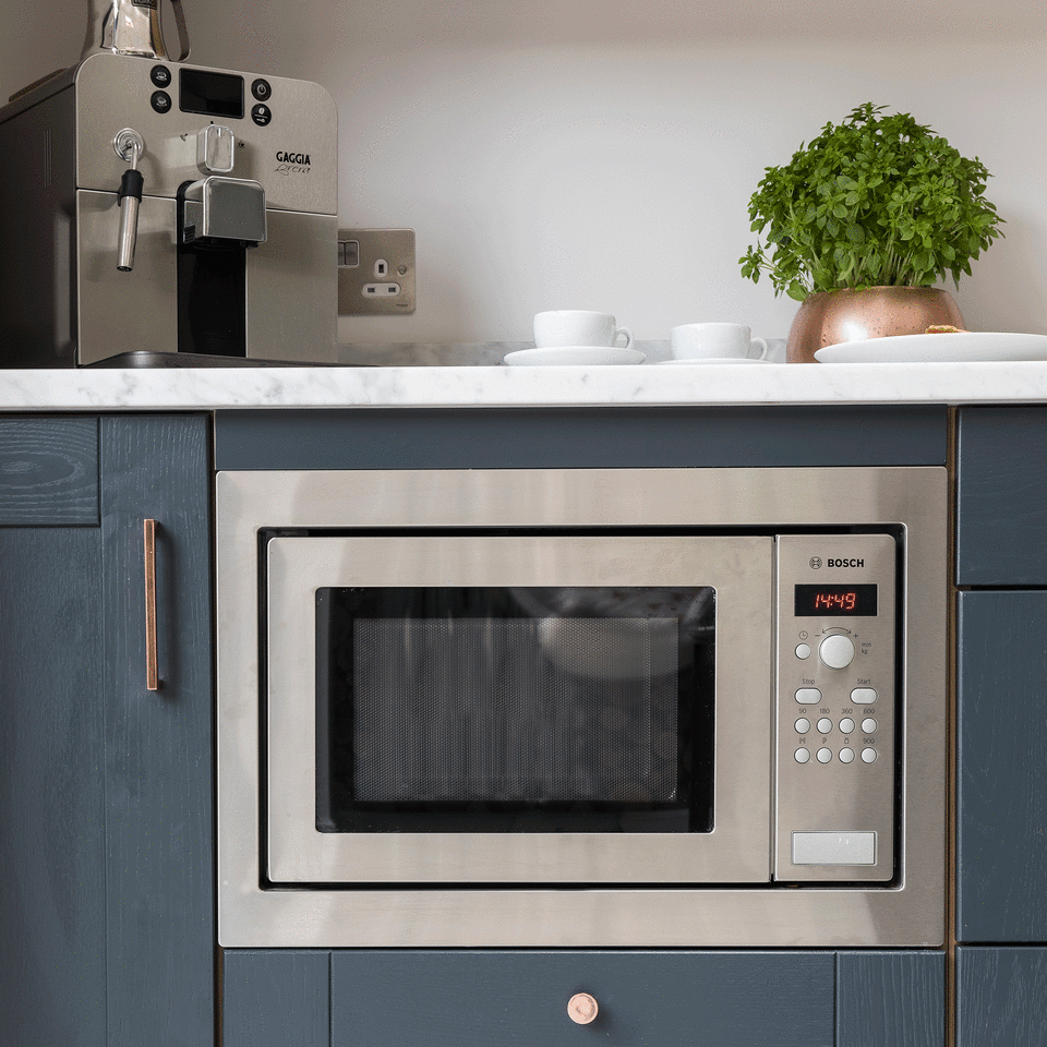 Silver microwave in blue kitchen
