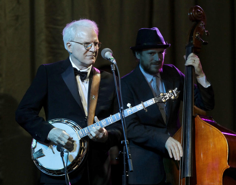 FILE - In this Saturday, March 23, 2013, file photo, honored guest Steve Martin, left, performs with his band The Steep Canyon Rangers at Muhammad Ali's Celebrity Fight Night XIX at the JW Marriott Desert Ridge Resort and Spa, in Phoenix. Martin and his bluegrass band are returning as one of the headliners for the Xerox Rochester International Jazz Festival in June. (Photo by Rick Scuteri/Invision/AP, File)