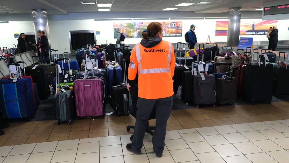 A Southwest Airlines employee watches over unclaimed baggage Tuesday at Will Rogers World Airport in Oklahoma City.