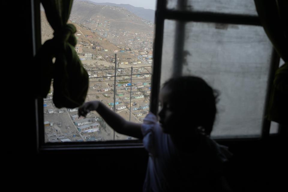 Zoe, Justina Flores' grandchild, plays inside of her home in the Pamplona Alta area in Lima, Peru, Monday, March 11, 2024. (AP Photo/Martin Mejia)