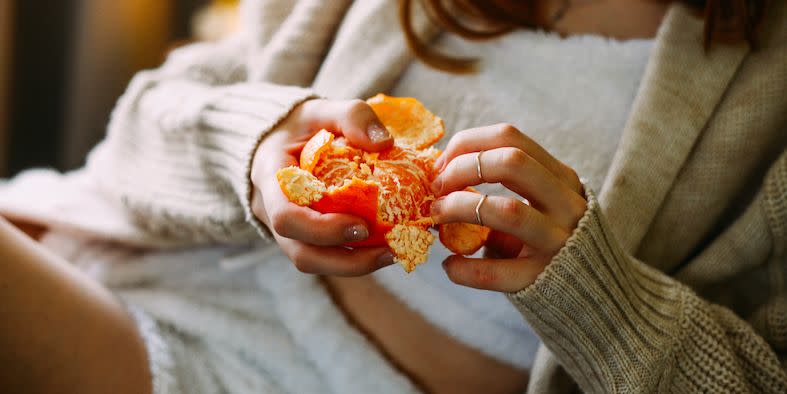 woman peeling orange to represent 'clean' eating