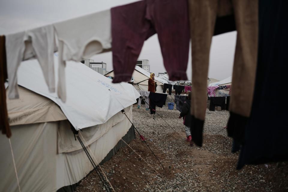 A woman displaced by fighting between Islamic State militants and security forces stands near her tent at a camp east of Mosul, Iraq, Wednesday, Feb. 15, 2017. The United Nations says they are temporarily pausing aid operations to neighborhoods in eastern Mosul retaken from the Islamic State group for security reasons as IS insurgent and counter attacks continue to inflict heavy civilian casualties there.(AP Photo/Bram Janssen)