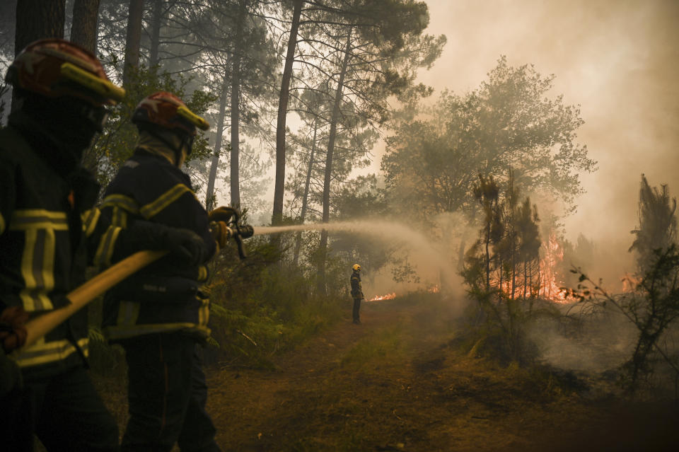 Firefighters puts water on a trees at a forest fire near Louchats, 35 kms (22 miles) from Landiras in Gironde, southwestern France, Monday, July 18, 2022. France scrambled more water-bombing planes and hundreds more firefighters to combat spreading wildfires that were being fed Monday by hot swirling winds from a searing heat wave broiling much of Europe. With winds changing direction, authorities in southwestern France announced plans to evacuate more towns and move out 3,500 people at risk of finding themselves in the path of the raging flames. (Phillippe Lopez)