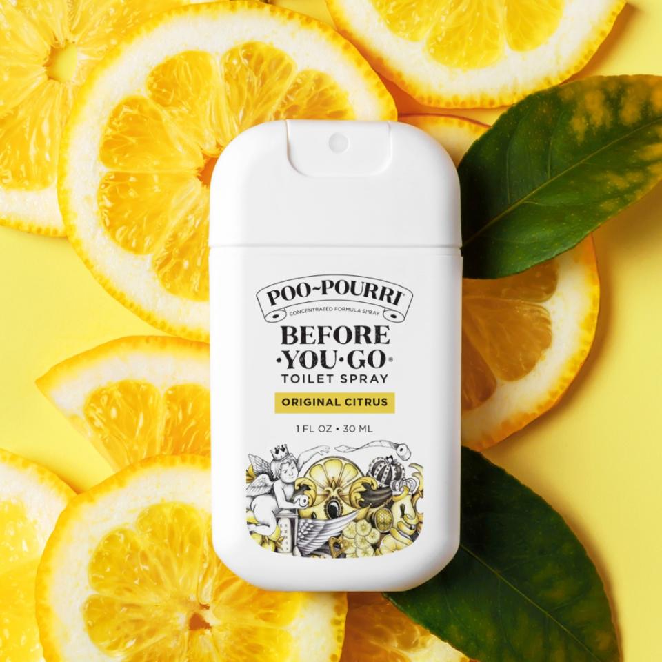 A bottle of Poo-Pourri Toilet Spray against a backdrop of citrus fruit slices