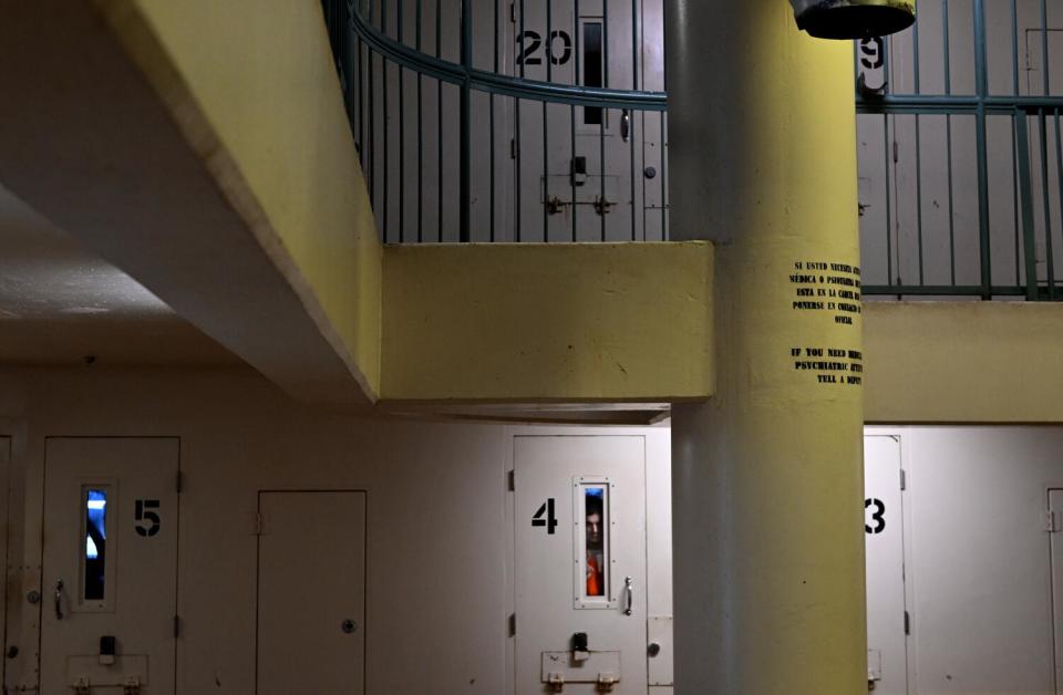 An inmate looks outside the glass window in his cell at the main jail in downtown Sacramento.