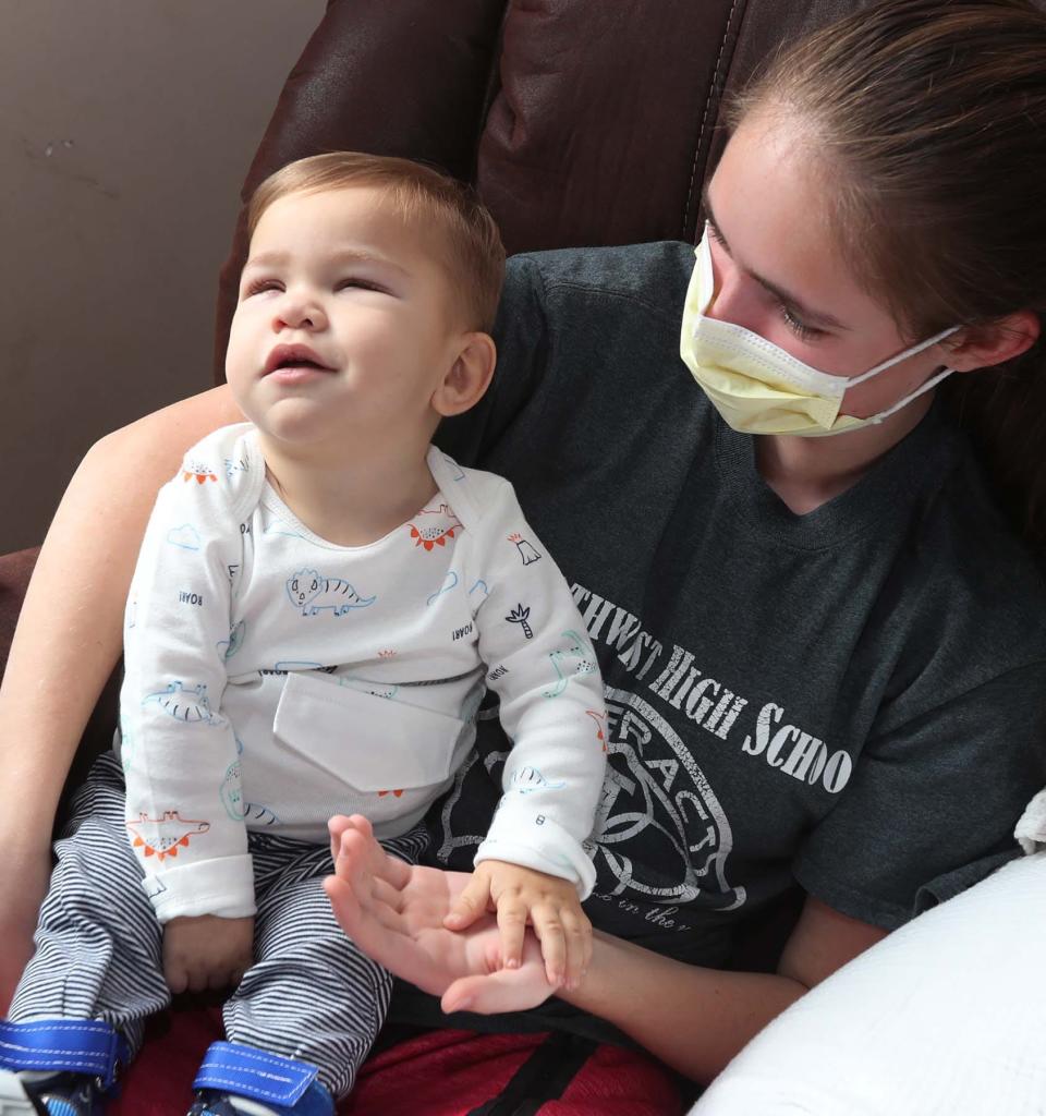 David Detwiler, 19 months, smiles while being held by family friend Vivian Freeman at the Detwiler home in Massillon.