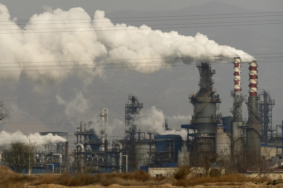 FILE - In this Nov. 28, 2019, file photo, smoke and steam rise from a coal processing plant in Hejin in central China's Shanxi Province. Chinese power companies bid for credits to emit carbon dioxide and other climate-changing gases as trading on the first national carbon exchange began Friday, July 16, 2021 in a step meant to help curb worsening pollution. (AP Photo/Olivia Zhang, File)