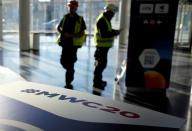 Employees work next to a banner with information of MWC20 in Barcelona