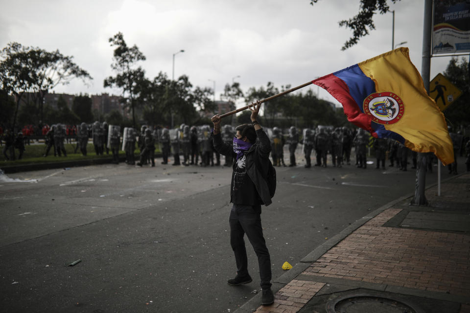 An anti-government protester waves a Colombia national flag during a protest in Bogota, Colombia, Thursday, Nov. 21, 2019. Colombia's main union groups and student activists called for a strike to protest the economic policies of Colombian President Ivan Duque government and a long list of grievances. (AP Photo/Ivan Valencia)