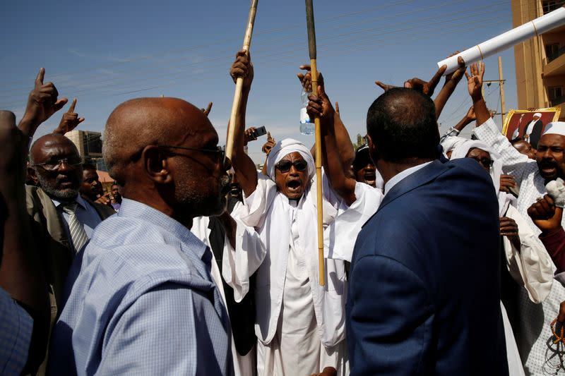 Supporters of Sudanese former president Omar Hassan al-Bashir shout slogans during a protest outside the court house that convicted him on corruption charges in Khartoum