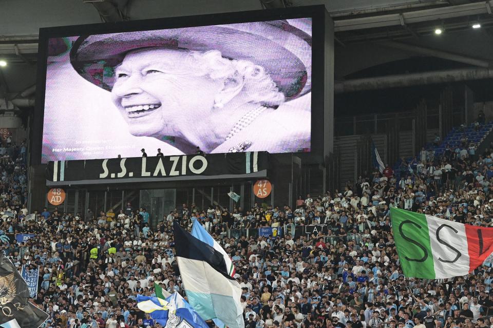 <p>A portrait of Britain's Queen Elizabeth II is displayed on a giant screen following the announcement of her death, prior to the start of the UEFA Europa League Group F first leg football match between SS Lazio and Feyenoord Rotterdam at the Olympic stadium in Rome on September 8, 2022. (Photo by Vincenzo PINTO / AFP) (Photo by VINCENZO PINTO/AFP via Getty Images)</p> 