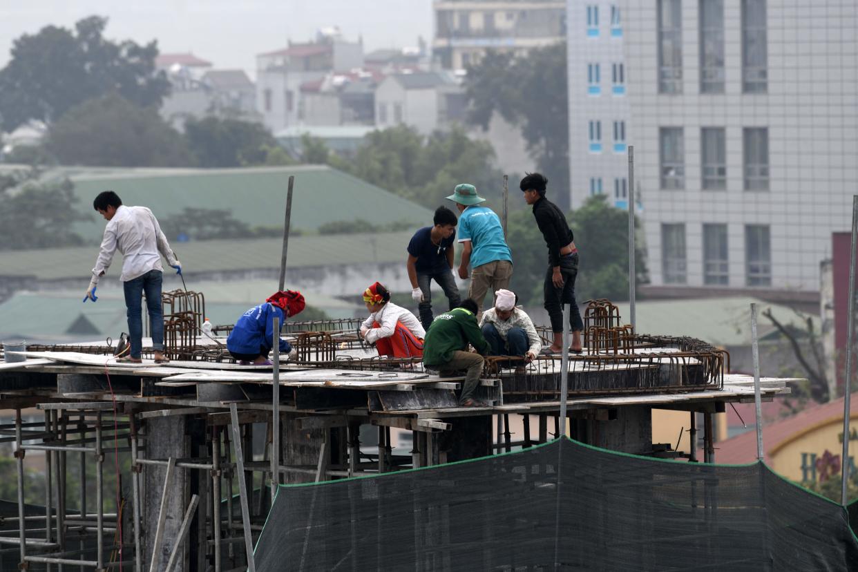 Laborers work at a construction of a low rise building in Hanoi on April 20, 2018. (Photo: ROSLAN RAHMAN/AFP/Getty Images)