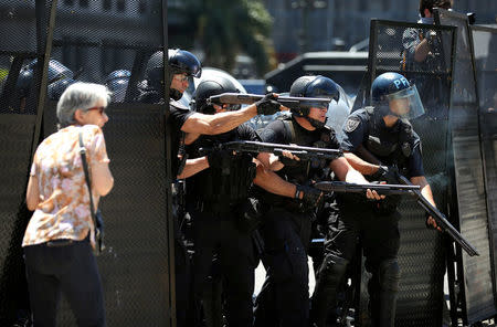 A woman reacts as Argentine policemen fire rubber bullets during clashes outside the Congress in Buenos Aires, Argentina December 14, 2017. REUTERS/Agustin Marcarian