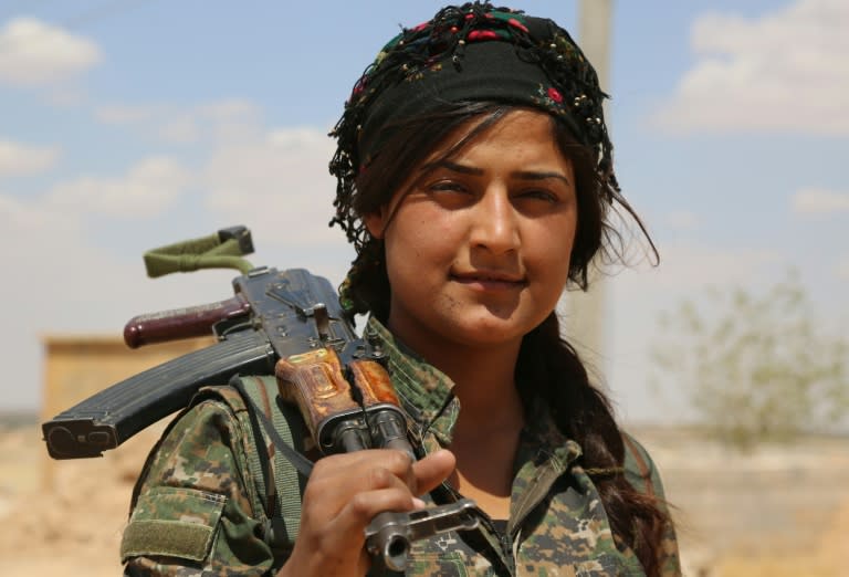 A fighter from the Kurdish People's Protection Units holds her weapon in Fatisah in the northern Syrian province of Raqa on May 25, 2016