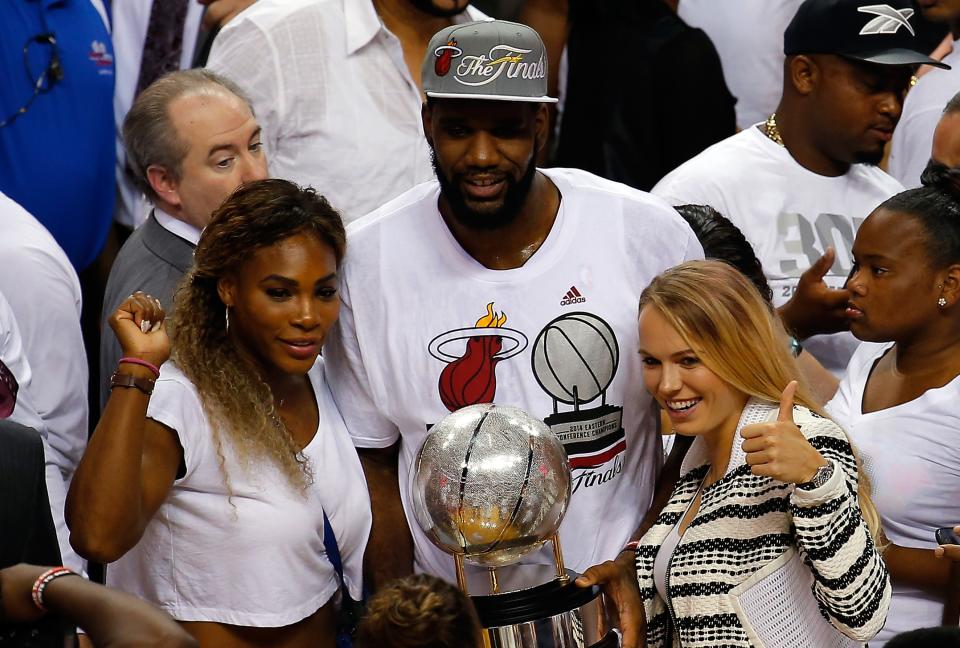 Williams and Wozniacki celebrate with Greg Oden of the Miami Heat after Game 6 of the NBA's Eastern Conference finals. (Photo by Chris Trotman/Getty Images)