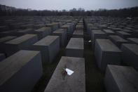 Roses with a note saying "#weremember", are placed on the Holocaust Memorial on International Holocaust Remembrance Day, in Berlin, Germany, Wednesday, Jan. 27, 2021. (AP Photo/Markus Schreiber)