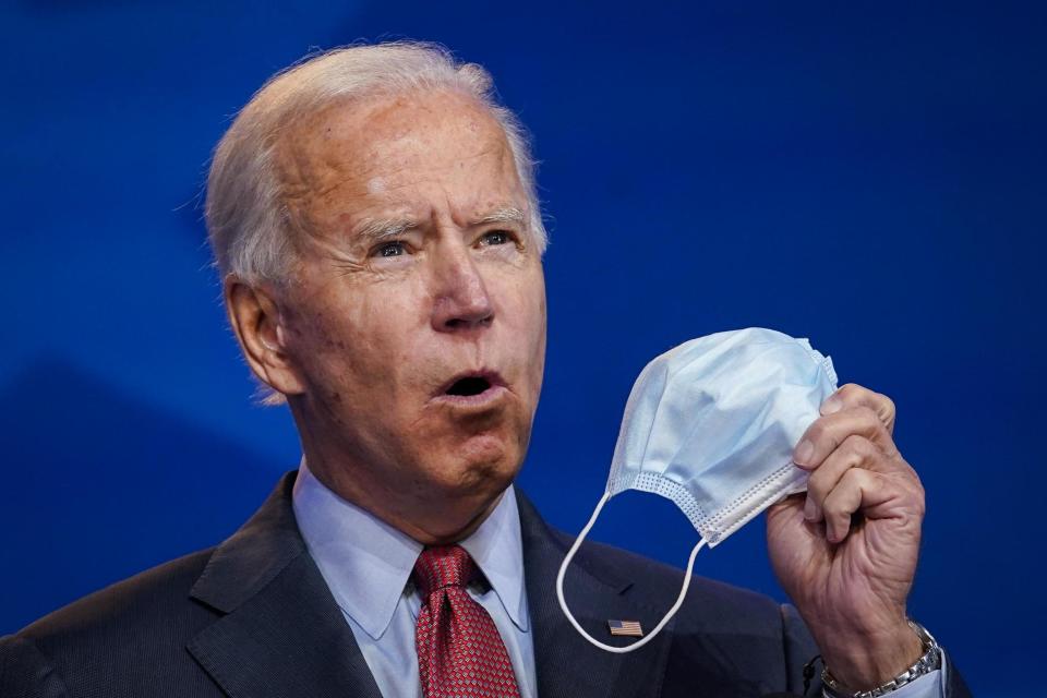 Joe Biden holds up a face mask as he speaks in Wilmington, Delaware (Getty Images)