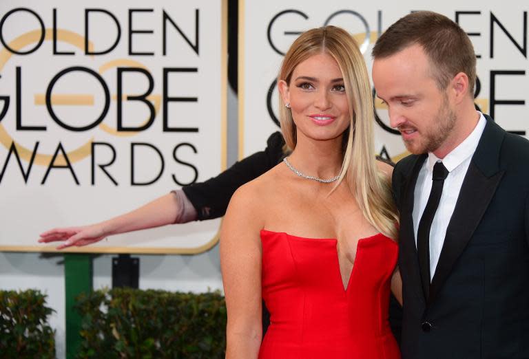 Actor Aaron Paul (R) and wife Lauren Parsekian arrive on the red carpet of the 71st Annual Golden Globe Awards in Beverly Hills, California, on January 12, 2014