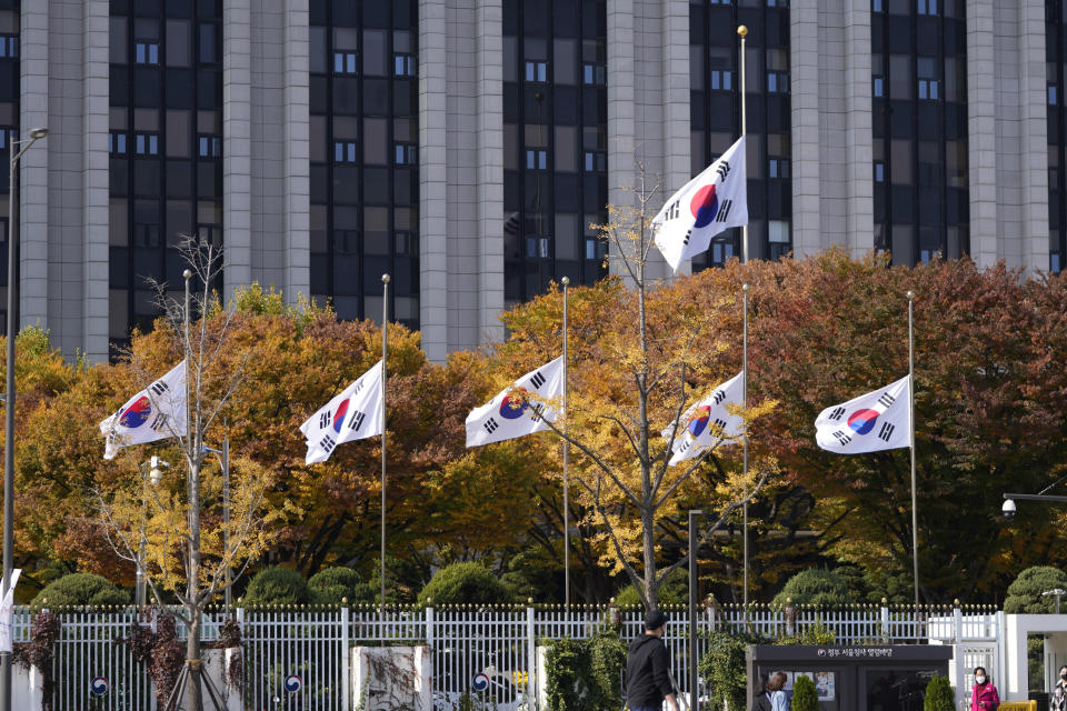 South Korean national flags fly at half-mast at the government complex in Seoul, South Korea, Sunday, Oct. 30, 2022. A mass of mostly young people celebrating Halloween festivities in Seoul became trapped and crushed as the crowd surged into a narrow alley, killing dozens of people and injuring dozens of others in South Korea's worst disaster in years. (AP Photo/Lee Jin-man)