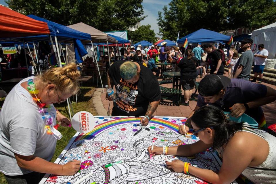 Attendees draw on a large coloring page set out during the annual Lexington Pride Festival in front of the Robert Stephens Courthouse in Lexington, Ky., Saturday, June 25, 2022.