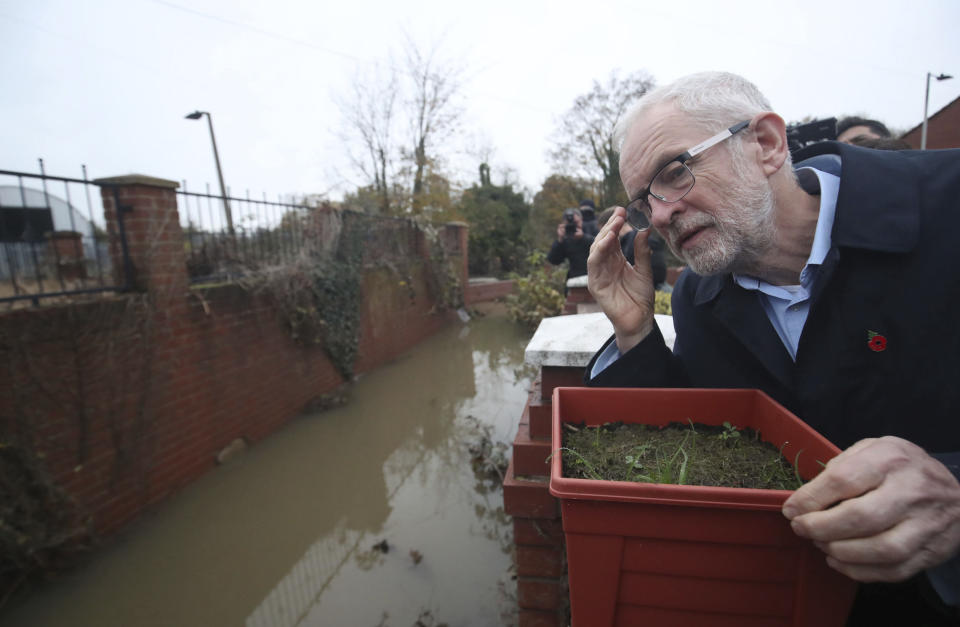 Labour leader Jeremy Corbyn looks at the effects of flooding during a visit to Conisborough, South Yorkshire, England, Saturday, Nov. 9, 2019. British political leaders swapped blame Saturday over floods that have drenched parts of England as the deluge became an issue in the campaign for the Dec. 12 election. (Danny Lawson/PA via AP)