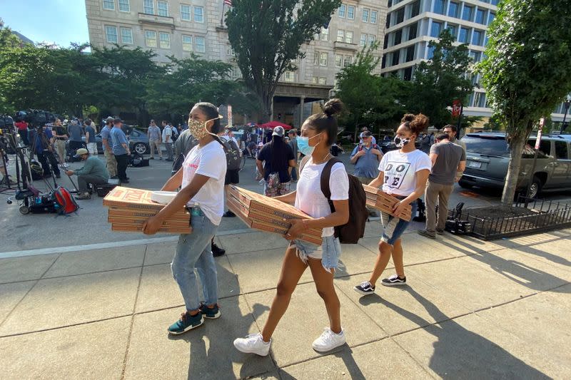 Volunteers carry boxes of pizzas to protesters in Washington