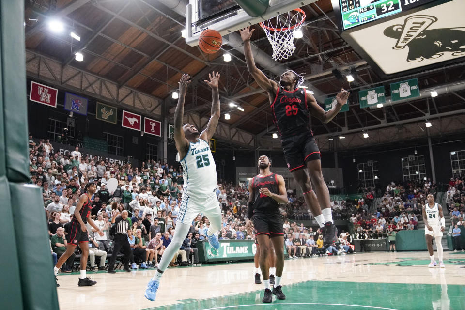 Tulane guard Jaylen Forbes (25) and Houston forward Jarace Walker (25) battle under the basket during the second half of an NCAA college basketball game in New Orleans, Tuesday, Jan. 17, 2023. (AP Photo/Gerald Herbert)