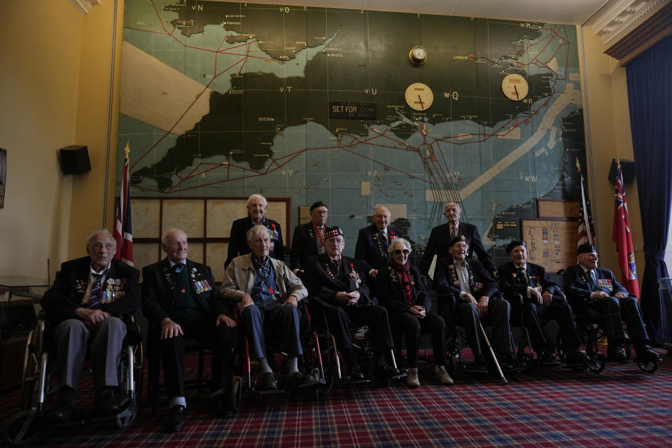 Normandy campaign veterans pose in the 'Map Room' which shows the large diagram of the D-Day invasion plans, at Southwick army base near Portsmouth, England, Monday, June 3, 2024. The map was used by Naval planners under the command of of British Admiral Bertram Ramsay. (AP Photo/Alastair Grant)