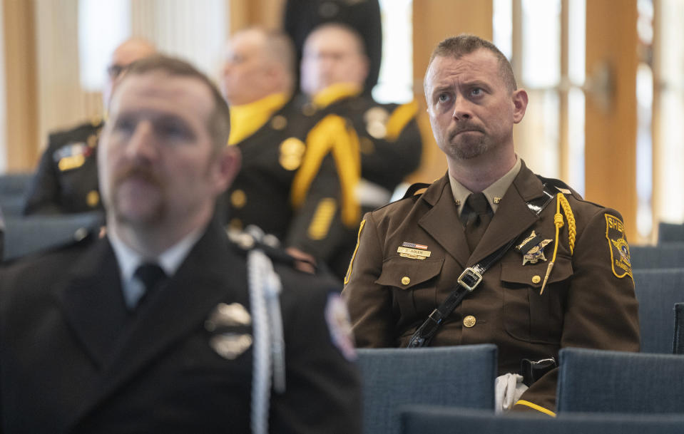 Jeremy Bolen, a commander in the Public Safety Services Division at Ramsey County Sheriff's Office, watches a live stream of a memorial service for Burnsville police officers Paul Elmstrand, 27, Matthew Ruge, 27, and firefighter-paramedic Adam Finseth, 40, at Prince of Peace in Burnsville, Minn., on Wednesday, Feb. 28, 2024. (Alex Kormann/Star Tribune via AP)