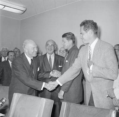Actors Charlton Heston, right, and future President Ronald Reagan, second from right, shake hands with leaders of the Association of Motion Picture Producers after the Screen Actors Guild ended its 1960 strike against seven movie studios. <a href="https://www.gettyimages.com/detail/news-photo/hollywood-ca-academy-award-winner-charlton-heston-shakes-news-photo/515261244?adppopup=true" rel="nofollow noopener" target="_blank" data-ylk="slk:Bettmann via GettyImages;elm:context_link;itc:0;sec:content-canvas" class="link ">Bettmann via GettyImages</a>