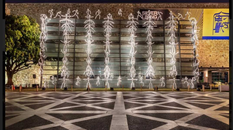 法國的萊普斯團隊讓一百個燈管小人爬上美術館牆面。
