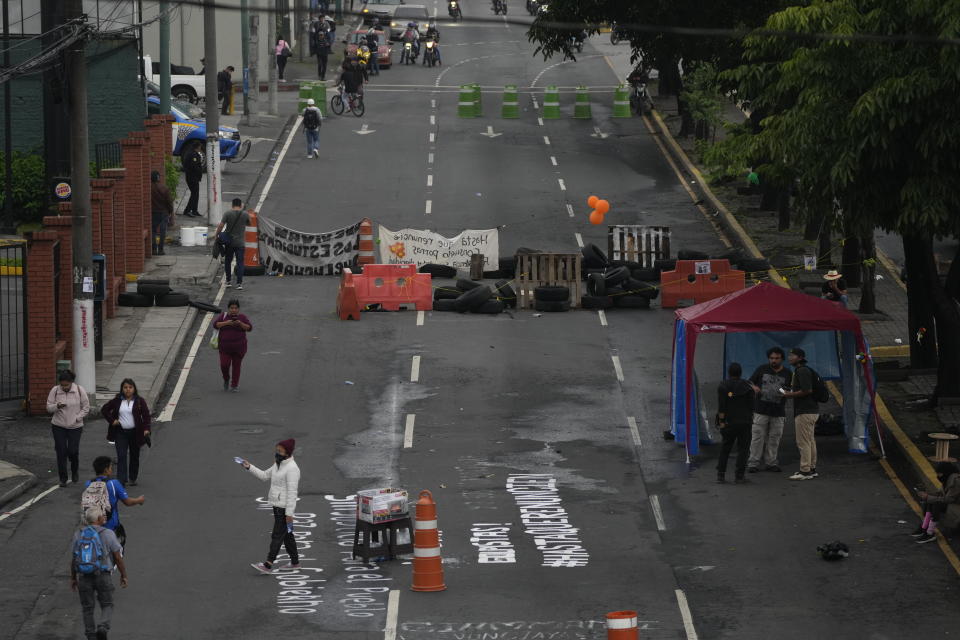 Una calle es bloqueada por manifestantes durante una huelga nacional frente a la Universidad Nacional en la Ciudad de Guatemala, la madrugada del lunes 9 de octubre de 2023. Las protestas no ceden para demandar la renuncia de la fiscal general y de un juez, a quienes señalan de intentar evitar que el presidente electo Bernardo Arévalo tome posesión en enero mediante distintas maniobras jurídicas. (Foto AP/Moisés Castillo)