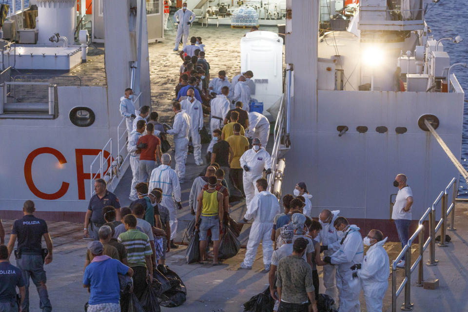 Migrants wait to board an Italian Coast Guard ship in the Sicilian Island of Lampedusa, Italy, Wednesday, Aug. 3, 2022. Italy's former firebrand interior minister, Matteo Salvini, is campaigning to get his old job back. Salvini is making a stop Thursday on Italy's southernmost island of Lampedusa, the gateway to tens of thousands of migrants arriving in Italy each year across the perilous central Mediterranean Sea. (AP Photo/David Lohmueller)