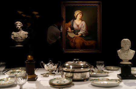 A member of Sotheby's staff poses for a photograph with a portrait of Emma Hamilton which forms part of the sale of items celebrating Nelson's Legend, including a dinner set called the Matcham desert service, in London, Britain January 11, 2018. REUTERS/Peter Nicholls